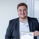Junger Mann im dunklen Anzug und weißen Hend