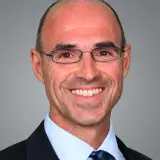 Schlanker Mann mit wenig Haar und Brille