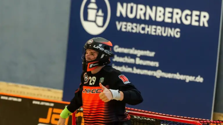 Floorball-Spieler vor Logo der NÜRNBERER Versicherung