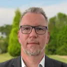 Mann in dunklem Anzug und weißen Hemd