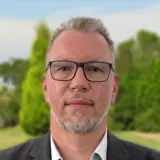 Mann in dunklem Anzug und weißen Hemd