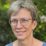Frau mit kurzen dunkelblonden Haaren
