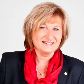Frau mit kurzen blonden Haaren und rotem Schal