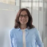 Frau mit schulterlangen rotbraunen Haaren und Brille