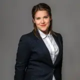 Frau mit dunkelblonden Haaren und dunklem Blazer