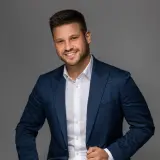 Jüngerer Mann mit Dreitagebart und blauem Blazer