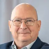 Mann mit Anzug und Brille mit verschränkten Armen