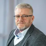 Mann mit Brille und grauem Anzug