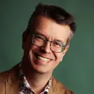Mann mit Brille und braunem Sakko
