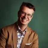 Mann mit Brille und braunem Sakko