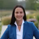 Junge Frau mit braunen Haaren und blauem Blazer