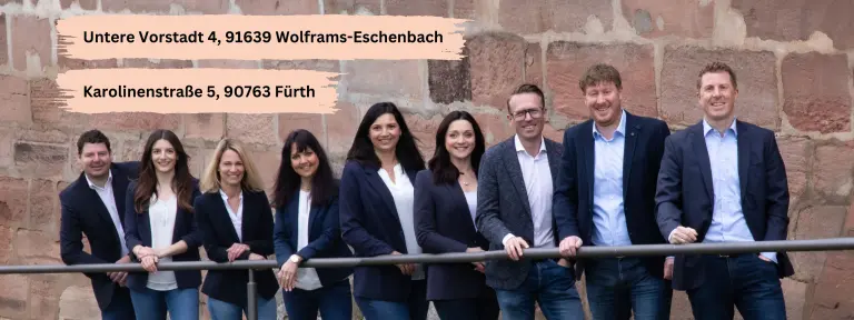 11 Personen in Businesskleidung stehen lächelnd nebeneinander