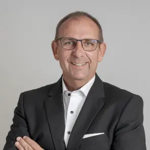 Mann mit Brille im schwarzen Anzug