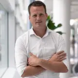 Mann mit weißem Hemd und verschränkten Armen