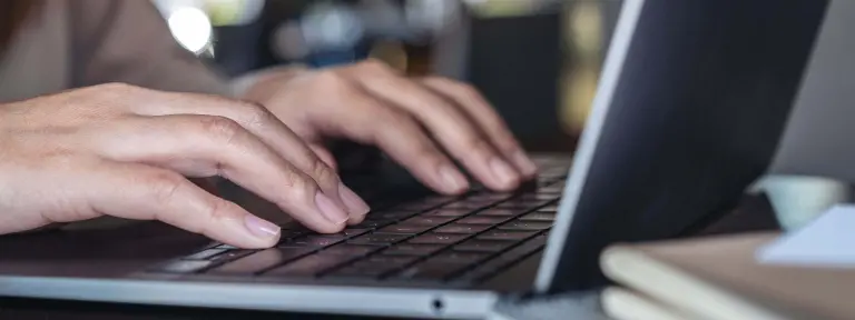 Hände an Laptop-Tastatur