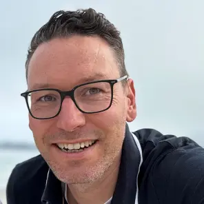 Mann mit Brille und blauem Poloshirt