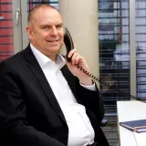 Telefonierender Mann mit wenig Haar