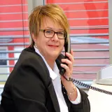 Telefonierende rotblonde Frau mit Brille