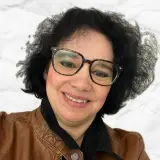 Frau mit dunklen Haaren und brauner Lederjacke