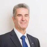 Grauhaariger Mann mit blauer Krawatte