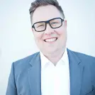 Mann mit Brille in blauem Anzug