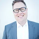 Mann mit Brille in blauem Anzug