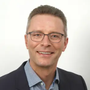 Lächelnder Mann mit kurzen Haaren und Brille