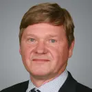 Blonder Mann mit gestreiftem Hemd und dunklem Sakko