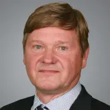 Blonder Mann mit gestreiftem Hemd und dunklem Sakko