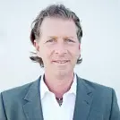 Dunkelblonder Mann mit graublauem Jackett