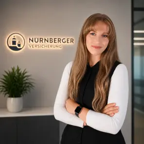 Frau mit langen Haaren und verschränkten Armen steht vor einem Wand, im Hintergrund ist eine Pflanze und das Logo der NÜRNBERGER Versicherung