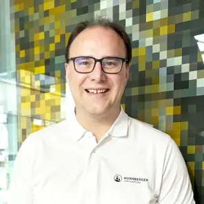 Mann mit Brille und weißem Hemd lächelt