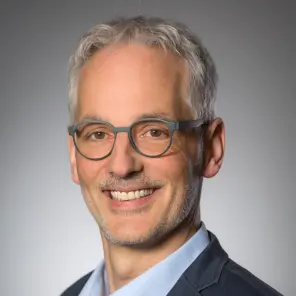 Schlanker grauhaariger Mann mit Brille