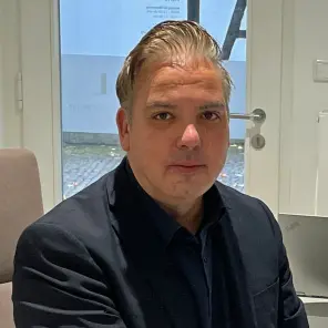 Mann im dunklen Anzug am Schreibtisch