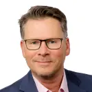 Dunkelblonder Mann mit eckiger Brille
