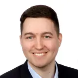Jüngerer Mann mit braunen Haaren und lila Krawatte