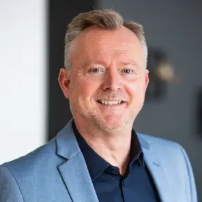 Grauhaariger Mann mit blauem Jackett