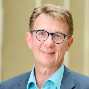 Blonder Mann mit blauer Brille