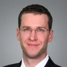 Schlanker Mann mit dunkelblonden Haaren und Brille