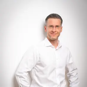 Schlanker Mann mit dunkelblonden Haaren und Brille
