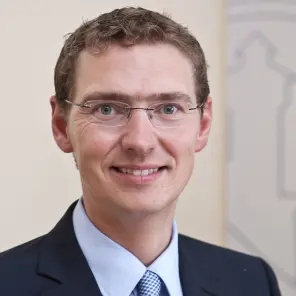 Lächelnder Mann mit Brille in Anzug