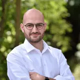 Jüngerer Mann mit Glatze, Brille und Bart