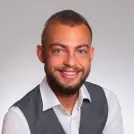 Ein lächelnder Mann mit Hemd und grauer Weste