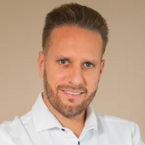 Junger Mann mit weißem Hemd und verschränkten Armen