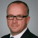 Mann mit Brille und blauer Krawatte