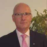Mann mit Glatze und rosa Krawatte
