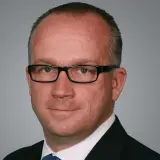 Mann mit Brille und blauer Krawatte