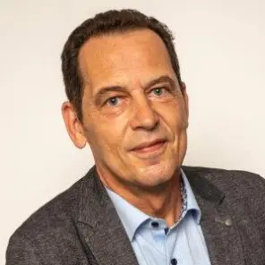 schlanker Mann mit hellblauem Hemd und grauem Sakko