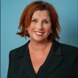 Frau mit roten Haaren und schwarzem Blazer