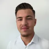 jüngerer Mann mit dunklen Haaren und weißem Hemd